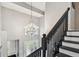 Bright foyer showcasing a crystal chandelier, staircase with black railing, and double doors at 12915 Carlington Ln, Riverview, FL 33579