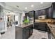 Spacious kitchen with stainless appliances, dark cabinets, and a center island, adjacent to the dining area at 12915 Carlington Ln, Riverview, FL 33579