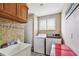 This functional laundry room features a utility sink, washer, dryer, and ample storage for household chores at 12915 Carlington Ln, Riverview, FL 33579