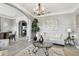 Elegant living room featuring gray walls, modern decor, chandelier, and tiled floors at 12915 Carlington Ln, Riverview, FL 33579