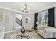 Stylish living room with modern furniture, gray walls, chandelier, and views of the front yard at 12915 Carlington Ln, Riverview, FL 33579