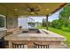 Outdoor kitchen featuring stone counter, grill, and built-in appliances, perfect for outdoor entertaining at 12915 Carlington Ln, Riverview, FL 33579