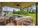 Outdoor kitchen with grill, sink, refrigerator and bar-style seating, overlooking the backyard at 12915 Carlington Ln, Riverview, FL 33579