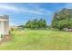 Spacious backyard features lush lawn and mature trees, providing ample space for recreation at 13311 Omega Ct, Dade City, FL 33525