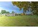 Large backyard with mature trees, playset, and lush green grass, great for entertaining at 13311 Omega Ct, Dade City, FL 33525
