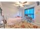 Bright bedroom with a ceiling fan, desk, and a cozy bed with colorful accents at 13311 Omega Ct, Dade City, FL 33525