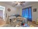 Bedroom featuring a ceiling fan, desk, and a cozy bed with playful decor at 13311 Omega Ct, Dade City, FL 33525
