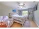 Comfortable bedroom featuring a queen-size bed, ceiling fan, and natural light from the window at 13311 Omega Ct, Dade City, FL 33525