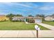 Attractive single-story home with well-manicured lawn and a quaint mailbox along the sidewalk at 13311 Omega Ct, Dade City, FL 33525