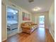 Inviting hallway featuring hardwood floors, neutral walls, and an access point to a bedroom and outdoor area at 13311 Omega Ct, Dade City, FL 33525