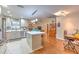 Spacious kitchen featuring white cabinets, a center island, and a seamless transition to the living and dining areas at 13311 Omega Ct, Dade City, FL 33525