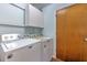 Bright laundry room features a Maytag washer/dryer, overhead cabinets, and a convenient side door at 13311 Omega Ct, Dade City, FL 33525