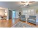 Inviting living room featuring wood-look floors, plush armchairs, and natural light from shuttered windows at 13311 Omega Ct, Dade City, FL 33525