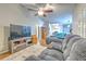 Spacious living room featuring plush seating, hardwood floors, and a seamless transition to the kitchen and dining area at 13311 Omega Ct, Dade City, FL 33525
