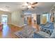 Open-concept living area with wood-look floors, comfortable seating, and views to the kitchen and lanai at 13311 Omega Ct, Dade City, FL 33525