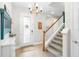 Bright foyer with staircase, featuring hardwood floors and modern chandelier, creating a welcoming entrance at 14672 Horse Trot Rd, Lithia, FL 33547
