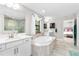 Elegant bathroom with a soaking tub, tiled floor, double vanity sinks, and a walk-in shower at 14672 Horse Trot Rd, Lithia, FL 33547