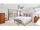 Bright bedroom with a ceiling fan, multiple windows, and decorative pillows atop a neatly arranged bed at 14672 Horse Trot Rd, Lithia, FL 33547