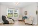Relaxing sitting room with massage chair, two cushioned chairs, two windows, and wood flooring at 14672 Horse Trot Rd, Lithia, FL 33547