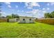 A view of the backyard with a carport and a new wooden fence at 2017 Waikiki Way, Tampa, FL 33619