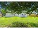 A view of backyard with green grass and white house at 2017 Waikiki Way, Tampa, FL 33619