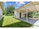 View of backyard with a carport, green grass, and chain link fence at 2017 Waikiki Way, Tampa, FL 33619