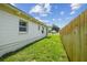 A fully fenced backyard with green grass and a freshly painted home exterior at 2017 Waikiki Way, Tampa, FL 33619