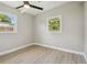 Bright bedroom featuring new light floors, 2 bright windows, and modern ceiling fan at 2017 Waikiki Way, Tampa, FL 33619
