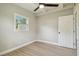 This bedroom features neutral walls, wood floors, a ceiling fan, and a window at 2017 Waikiki Way, Tampa, FL 33619