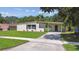 Charming home featuring a large front yard with a driveway and covered carport at 2017 Waikiki Way, Tampa, FL 33619
