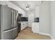 Well-lit kitchen with stainless steel refrigerator, white cabinets, dark backsplash, and modern fixtures at 2017 Waikiki Way, Tampa, FL 33619