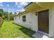 Side yard features a well-maintained lawn, home exterior, and convenient back door access at 2017 Waikiki Way, Tampa, FL 33619