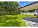 A serene backyard offers a covered patio, lush lawn, and privacy fencing for relaxation and outdoor enjoyment at 2027 Balfour Cir, Tampa, FL 33619