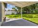 Large backyard with green lawn, shade trees and a covered patio with a concrete floor for entertainment at 2027 Balfour Cir, Tampa, FL 33619