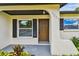 View of the home's entry featuring a solid front door, number, and small landscape details at 2027 Balfour Cir, Tampa, FL 33619