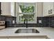 Close-up of a stainless steel sink with a black faucet and white quartz countertop at 2027 Balfour Cir, Tampa, FL 33619