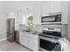 Kitchen with stainless steel appliances, granite countertops, and modern light fixture at 208 Se Lincoln N Cir, St Petersburg, FL 33703