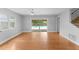 Open-concept living room with hardwood floors and sliding glass doors to the pool at 208 Se Lincoln N Cir, St Petersburg, FL 33703