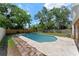 Backyard featuring a sparkling pool with a concrete patio and a wood fence line at 208 Se Lincoln N Cir, St Petersburg, FL 33703