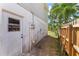 Side exterior view of a property with a white door, meter, and a wooden fence at 208 Se Lincoln N Cir, St Petersburg, FL 33703