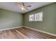 Bedroom featuring wood-look flooring, green walls, white trim, and shuttered windows at 2192 Robinson Dr, St Petersburg, FL 33710