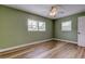 A spacious bedroom with green walls, luxury vinyl flooring and bright shuttered windows at 2192 Robinson Dr, St Petersburg, FL 33710