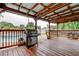 View of the pool from the wooden deck, which features a stainless steel grill and a metal roof at 2192 Robinson Dr, St Petersburg, FL 33710