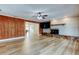 Spacious living room with a fireplace, wood paneling, and light-colored wood flooring at 2192 Robinson Dr, St Petersburg, FL 33710