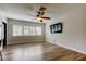 Bright living room with modern flooring, fan, and a large window with white plantation shutters at 2192 Robinson Dr, St Petersburg, FL 33710