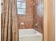 Bathroom with a white tub, brown tile, and a shower curtain at 2513 Martucci Rd, Seffner, FL 33584