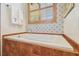 Bathroom with a soaking tub, wood framed window and tiled walls at 2513 Martucci Rd, Seffner, FL 33584