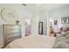 A well-lit bedroom featuring a dresser, comfortable bed, and doorways to the hall and bathroom at 2513 Martucci Rd, Seffner, FL 33584