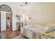 Bedroom features a four-poster bed, wood-look floors, and a view into an adjacent bathroom at 2513 Martucci Rd, Seffner, FL 33584