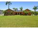 Charming single-story home features a well-manicured lawn and lush tropical landscaping with mature palm trees at 2513 Martucci Rd, Seffner, FL 33584